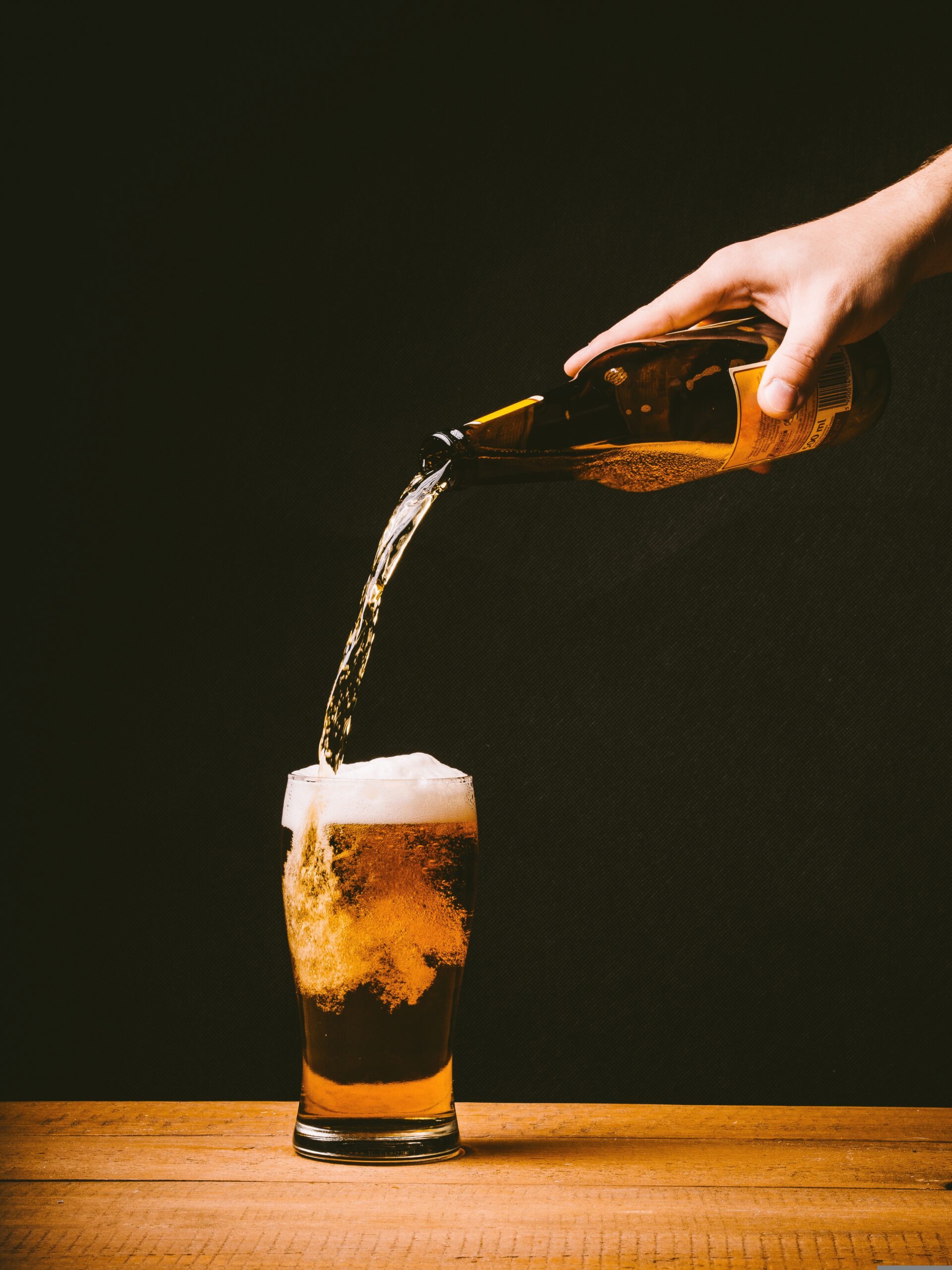 A person pouring beer into a glass.