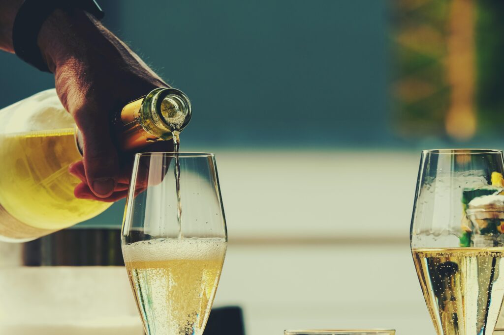 A person pouring champagne into two glasses.